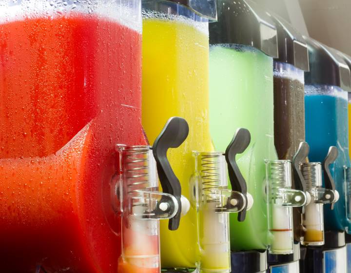 Row of slush machines filled with different brightly coloured drinks