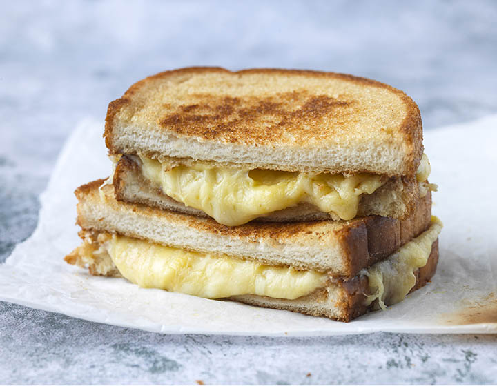 Two halves of a toastie with melting cheese oozing out
