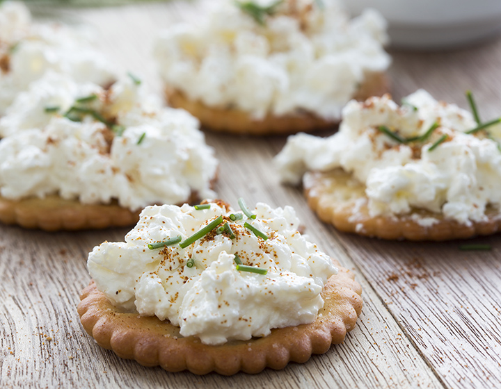 Crackers topped with cottage cheese and cayenne pepper