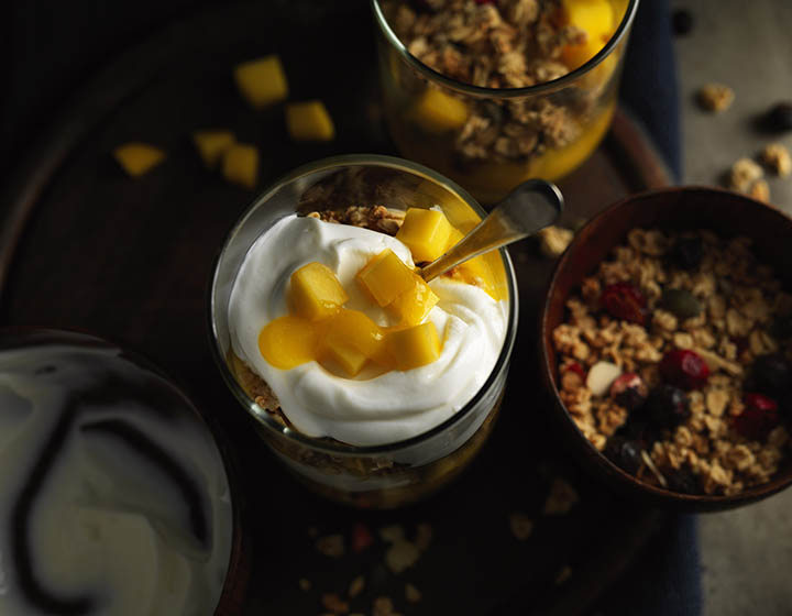 Yoghurt with yellow fruit and a bowl of granola