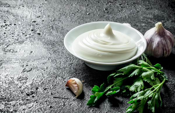 Mayonnaise with parsley and garlic. On black rustic background