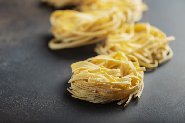 Traditional italian raw pasta tagliatelle, selective focus image