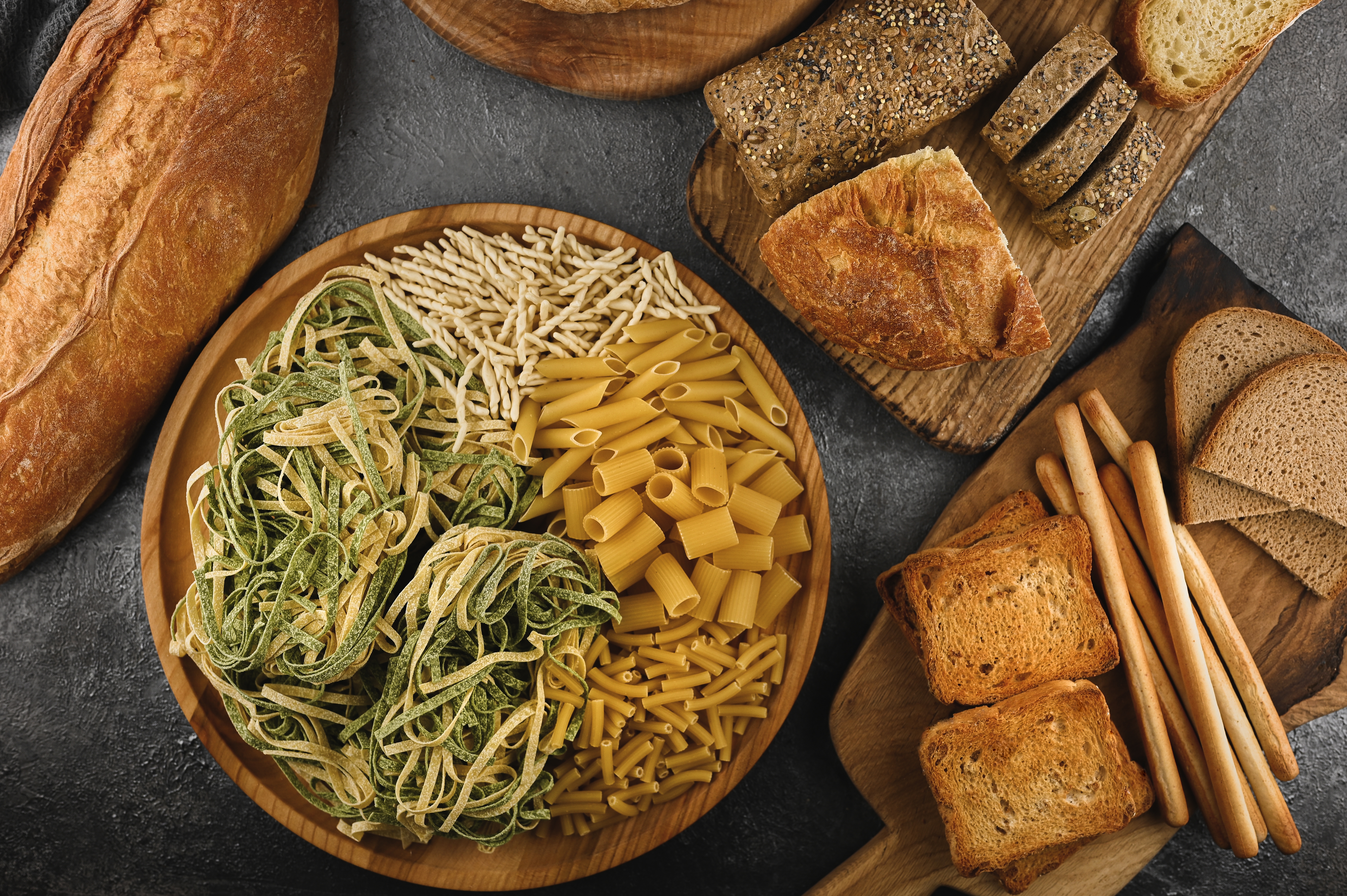 still life with bread, pasta and wheat. Selection of different italian types of pasta and bread flat lay. Many mixed breads