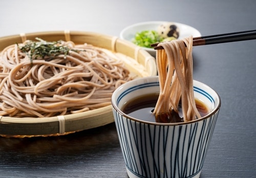 Zaru-soba placed on a black background. Soba noodles dipped in noodle soup. Zaru soba is a traditional Japanese food.