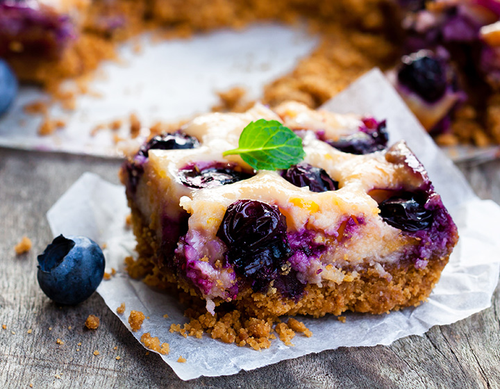 Slice of shortcrust pie with blueberries and mint leaf