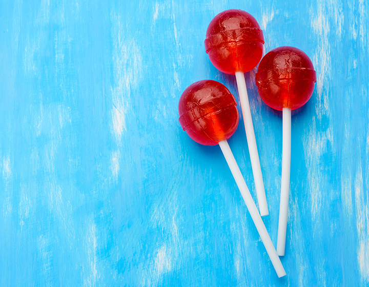 Three red lollipops on blue background