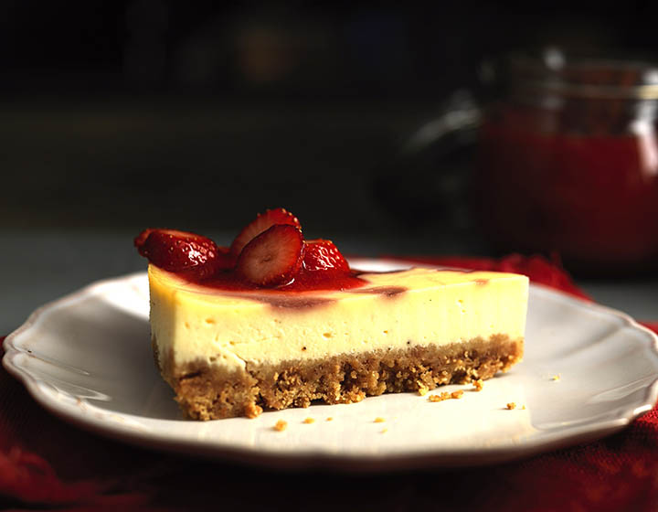 Slice of yellow cheesecake with a strawberry topping