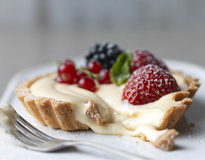 Cream filled tart dessert with fruit toppings 