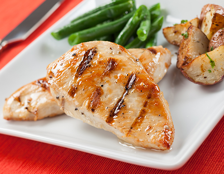 Glazed chicken breast with grill marks and vegetables