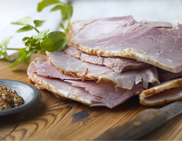 Slices of thick cut ham served with grainy mustard