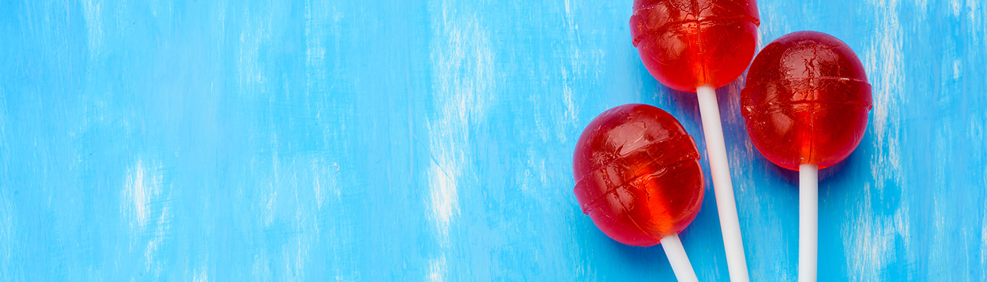 Three shiny red lollipops against a blue background