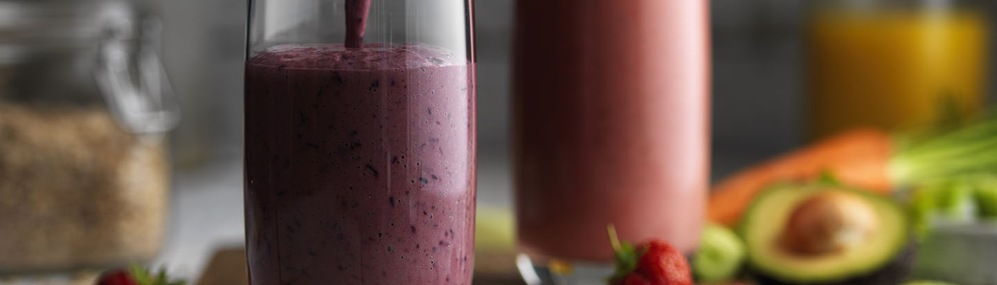 Pouring purple smoothie into a glass