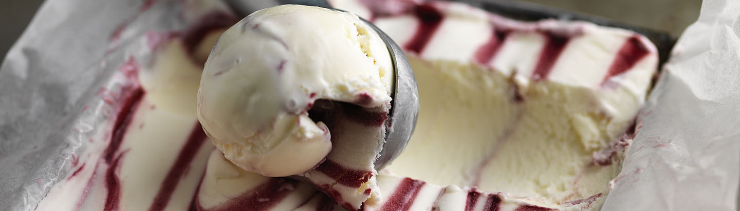 Ice cream scoop taking raspberry ripple ice cream