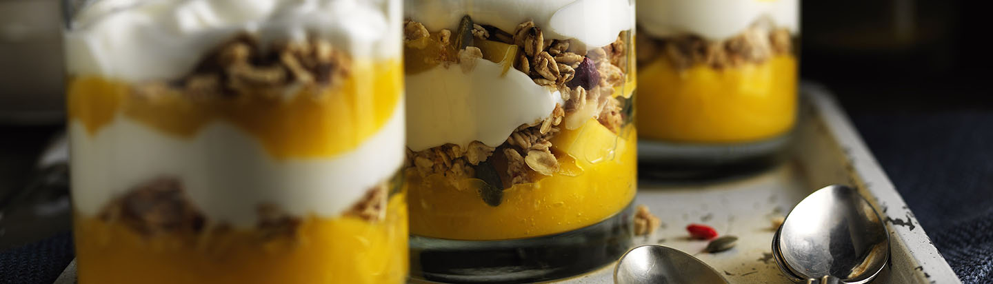 Tray of yoghurt desserts with fruit and granola