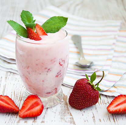 Strawberry yoghurt topped with fresh strawberries and mint