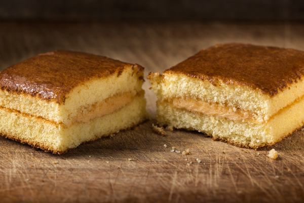 Sponge cake with fruit cream over wooden background