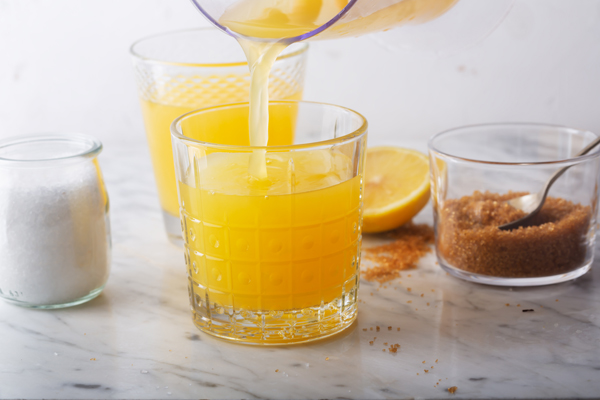 Homemade Isotonic Energy Drink and Ingredients. Glass With Yellow Liquid, Natural Sport Beverage on a Stone Background. It Usually Contains Salt and Sugar and Maintains Optimal Hydration