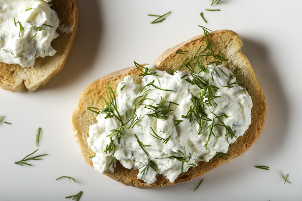 Open sandwich with toast and homande cheese cream with fresh dill - top view