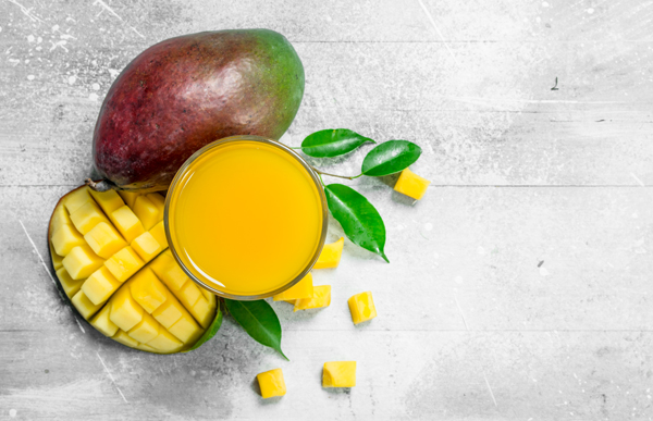 Mango juice in glass. On rustic background