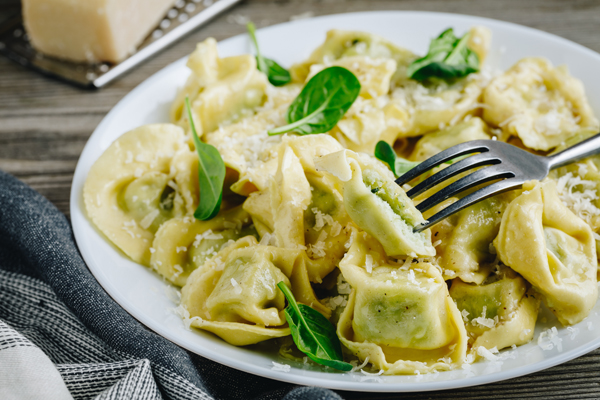 Italian ravioli pasta with spinach and ricotta on wooden rustic background