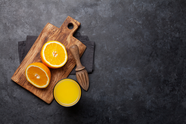 Fresh orange juice and oranges on stone table. Top view with copy space