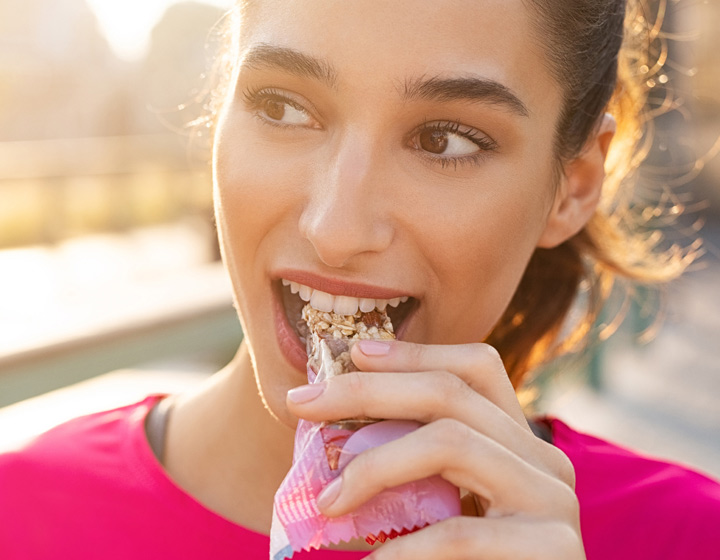 Woman eating healthy snack bar