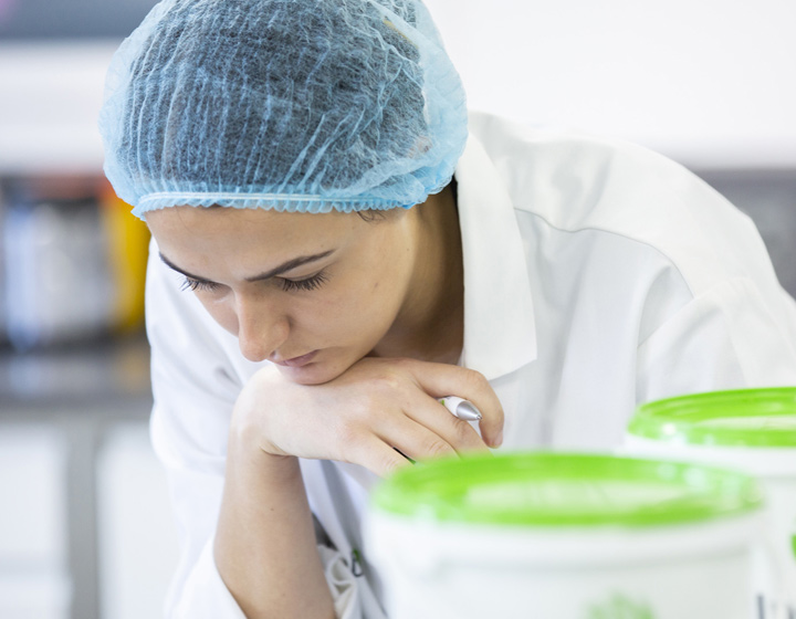 Scientist in hair net and lab coat