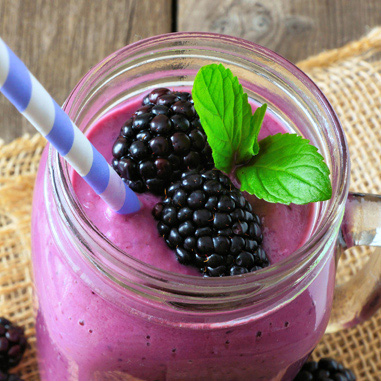 A purple smoothie with berries in a mason jar glass showing beverages in texturizer applications