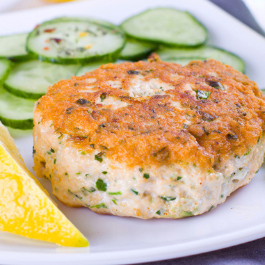Crab cake on a plate with cucumbers & lemon showing meat, seafood and poultry texturizer applications