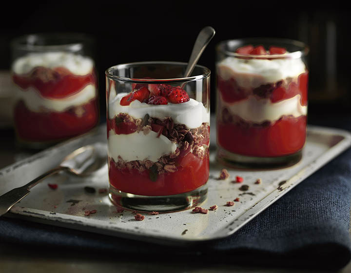 Two glasses of yoghurt with red fruit and granola