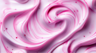 Close-up of smooth pink and white cream swirls with a glossy texture, resembling berry yogurt or whipped dessert