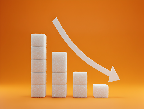 Stacked sugar cubes arranged as a descending bar chart with a downward arrow on an orange background, symbolizing reduced sugar consumption