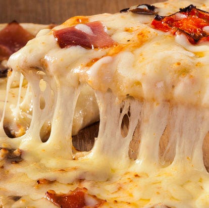 Pizza recién horneada con abundante queso derretido y jamón, receta italiana ideal para cenas caseras y comida rápida gourmet.