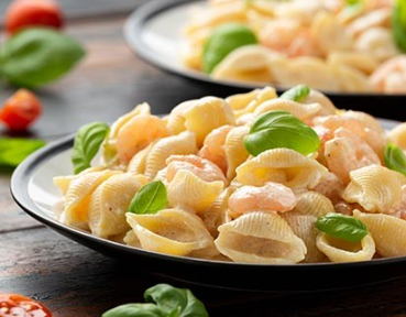 Close-up of creamy pasta with vegetables, showcasing savory ready meal applications.